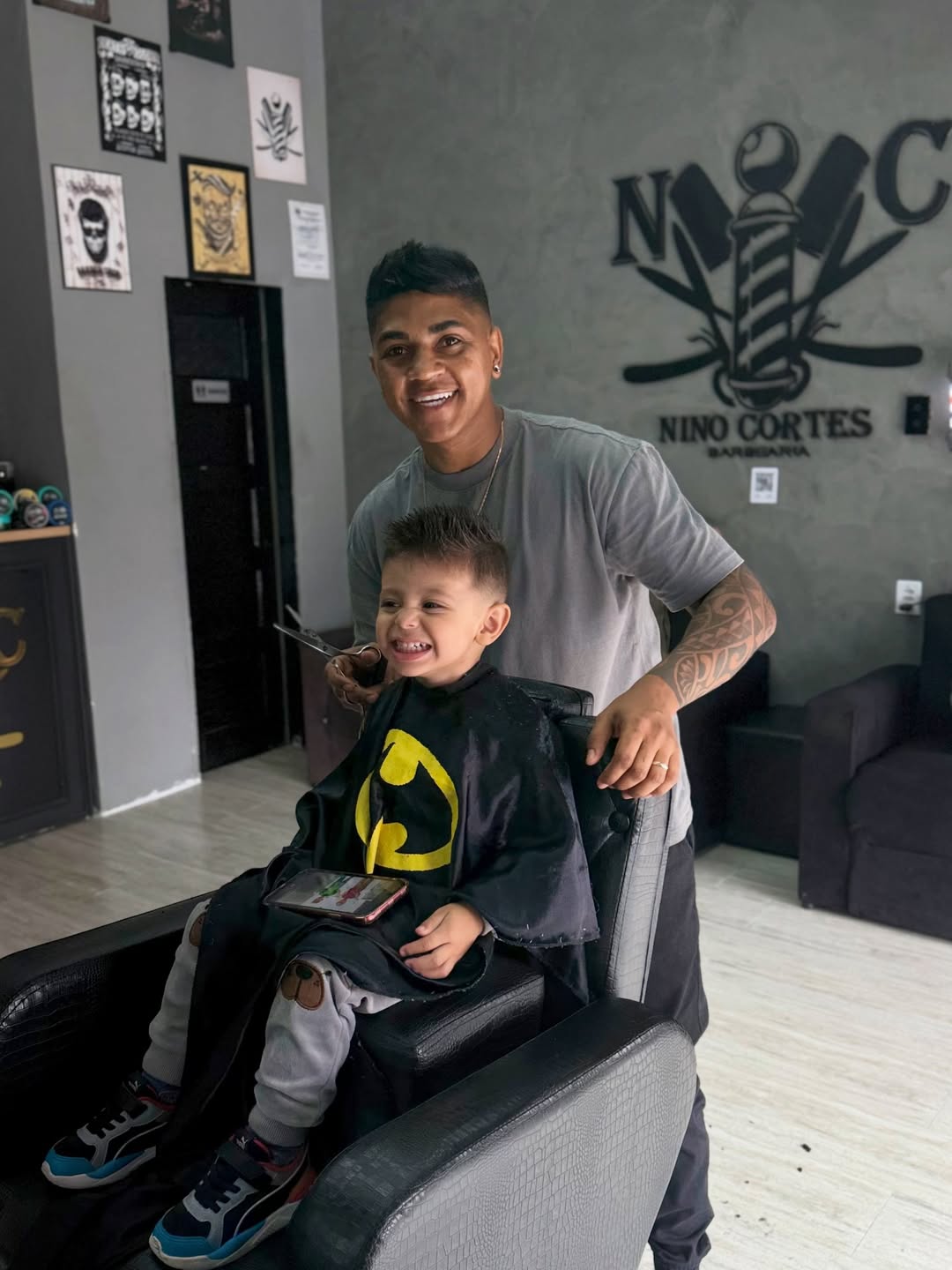 Nino Cortes cortando cabelo de cliente na barbearia